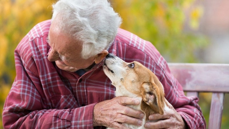 Elderly gentleman sitting with his dog.