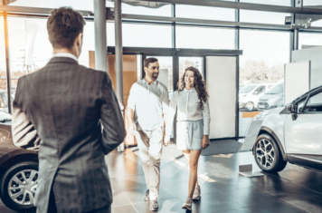 Couple walking into car dealership