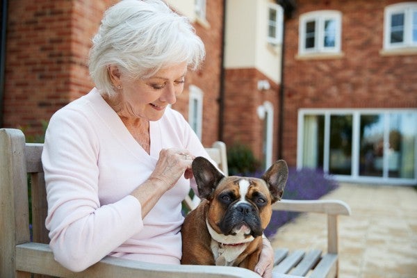 Woman sitting on a park bench with her dog.