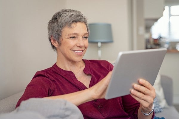 Woman leaving an assisted living review using her tablet.