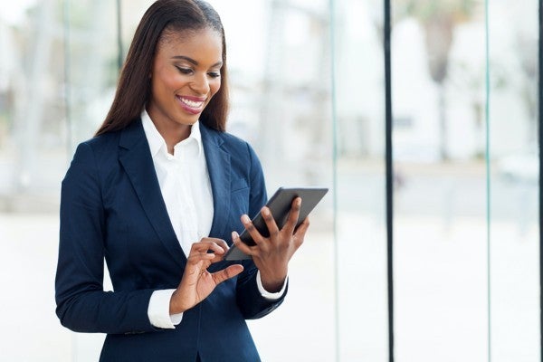 Smiling woman looking at a tablet.