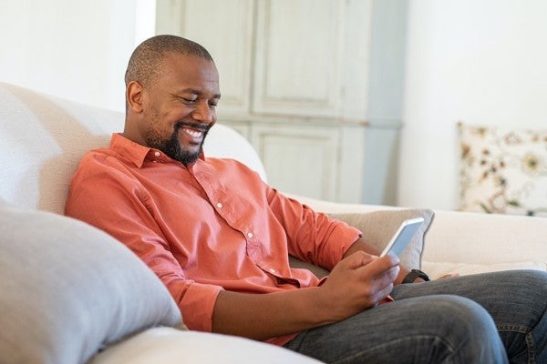 Man sitting on stairs looking at his phone.