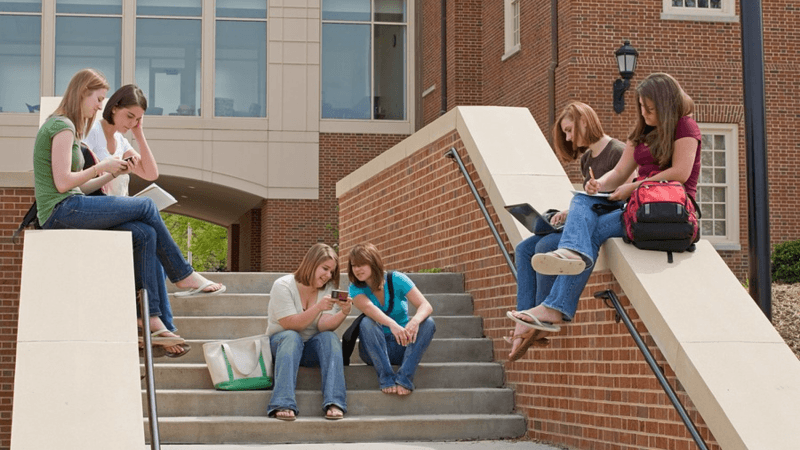 Group of university students sitting on steps.
