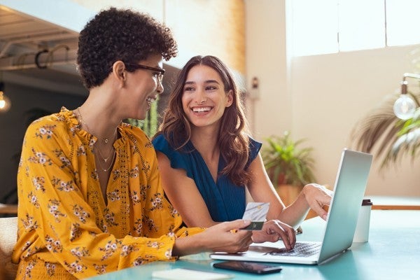 Smiling coworkers looking at a computer screen together.