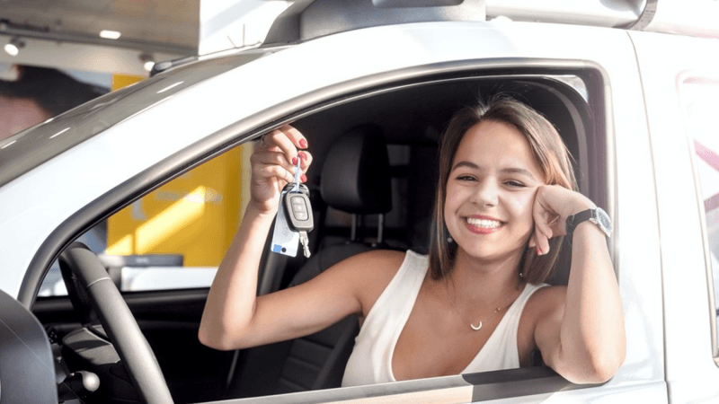 Smiling woman holding a new set of car keys.