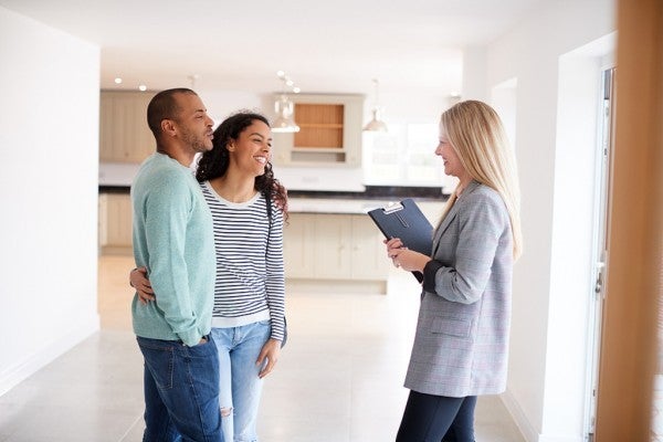 Couple meeting with a realtor in a new home.