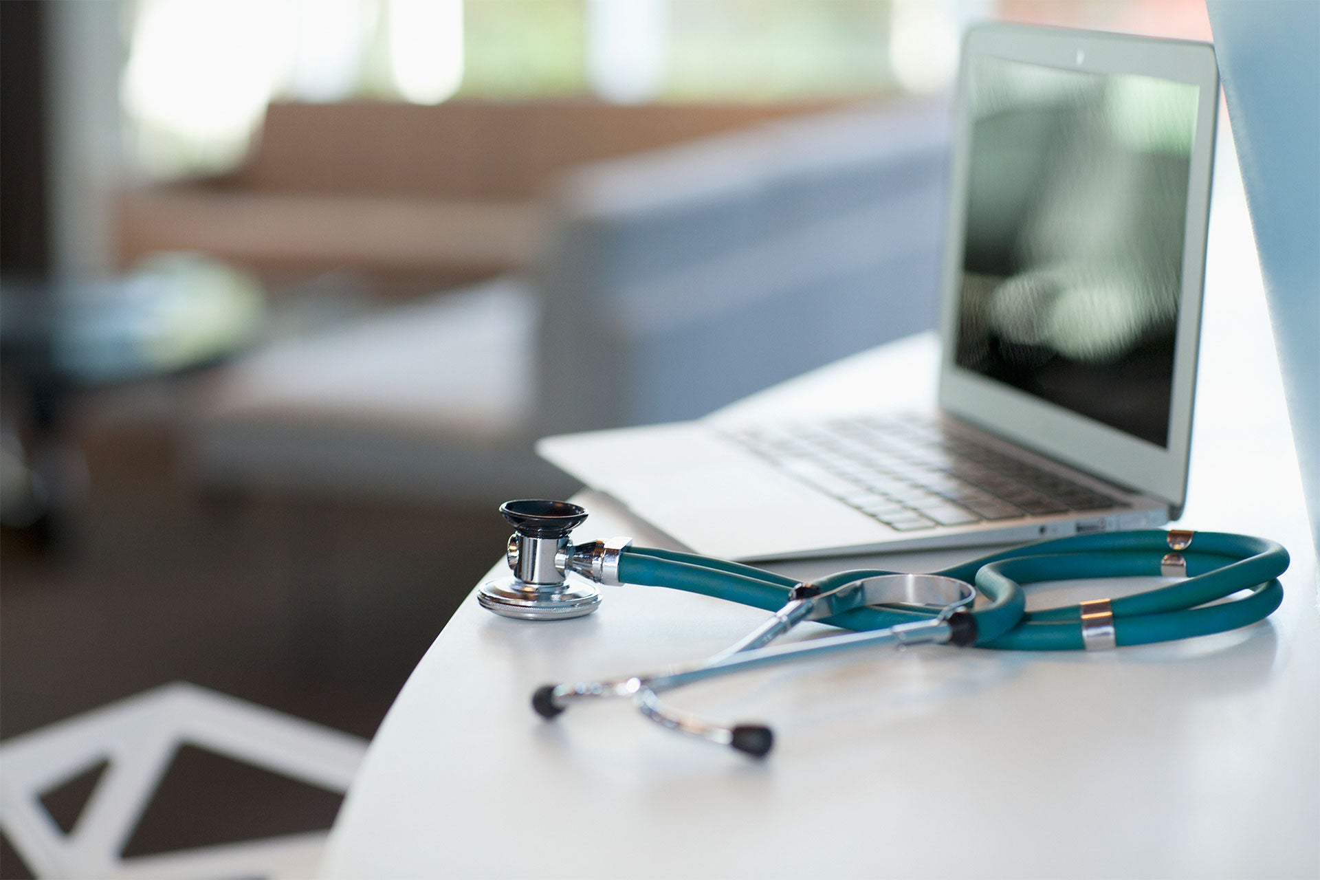 Stethoscope and laptop on desk.
