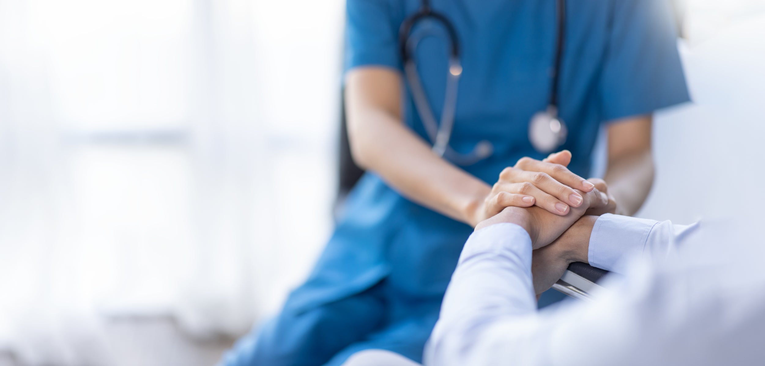 Cropped shot of a female nurse hold her senior patient's hand. Giving Support. Doctor helping old patient with Alzheimer's disease. Female carer holding hands of senior man