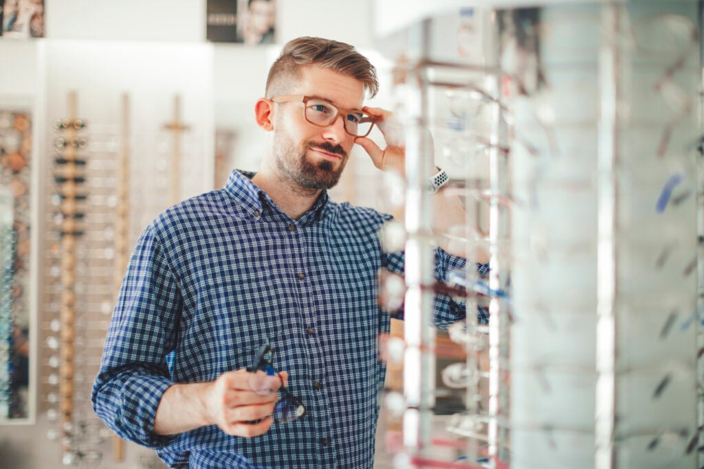 Man looking at glasses inside an opticians