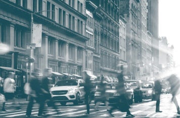 People walking across busy downtown intersection.