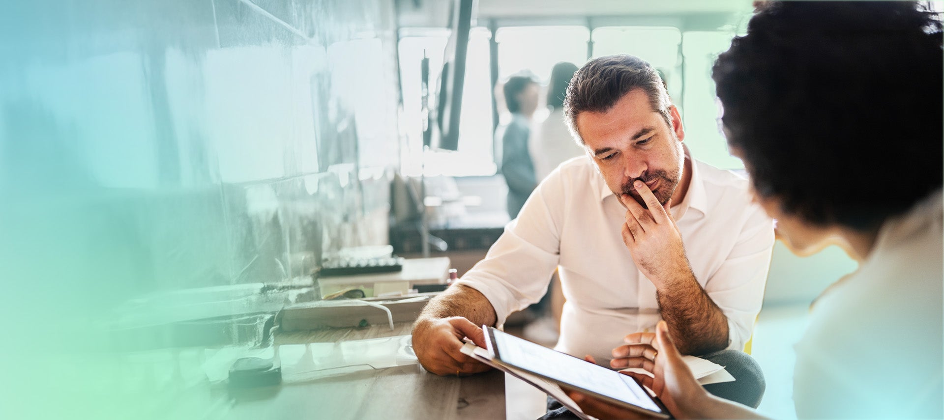 Man and woman reviewing data on tablet