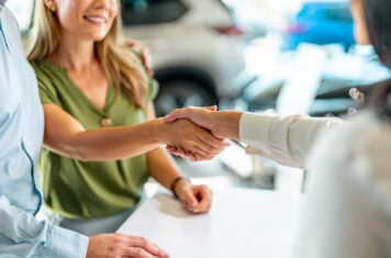 Female customer shaking hands with saleswoman