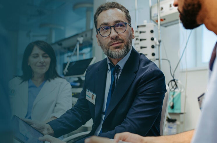 Doctors consulting a patient in a hospital room